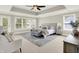 Spacious main bedroom with a tray ceiling, fan, sitting area, natural light, and neutral tones offering a relaxing haven at 7614 Bishops, Zionsville, IN 46077