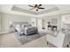 Neutral main bedroom featuring tray ceiling, sitting area, large bed, and soft natural light at 7614 Bishops, Zionsville, IN 46077