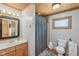 Well-lit bathroom features a wood ceiling, shower-tub combo, and modern fixtures at 775 Baker Rd, Martinsville, IN 46151