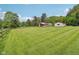 Sprawling lawn features lush greenery, complemented by a charming single-Gathering home with stone accents and rustic outbuildings at 775 Baker Rd, Martinsville, IN 46151