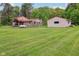 Exterior view of the charming home, featuring a lush lawn, stone accents, metal roof and an auxiliary building at 775 Baker Rd, Martinsville, IN 46151