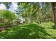 Spacious backyard with lush green lawn, mature trees offering plenty of shade, and garden beds at 7843 Windcombe Blvd, Indianapolis, IN 46240
