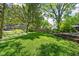 Well-maintained backyard with lush green lawn, mature trees, and garden beds at 7843 Windcombe Blvd, Indianapolis, IN 46240
