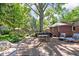 Relaxing backyard featuring a stone patio with outdoor seating and dining under mature trees at 7843 Windcombe Blvd, Indianapolis, IN 46240