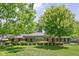Charming red brick home features a landscaped lawn, mature trees, and classic black shutters at 7843 Windcombe Blvd, Indianapolis, IN 46240