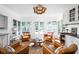 Sun-drenched sitting room with leather chairs, views of backyard, and an elegant light fixture at 7843 Windcombe Blvd, Indianapolis, IN 46240