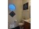 Half bathroom featuring a white toilet and sink, octagonal window, and two decorative wall art pieces at 8002 Windham Lake Way # 33, Indianapolis, IN 46214