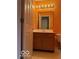 Traditional bathroom features warm orange textured walls, a wood vanity, and a framed mirror with decorative lighting at 8002 Windham Lake Way # 33, Indianapolis, IN 46214