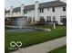 Exterior view of back of townhomes with a fountain in the pond at 8002 Windham Lake Way # 33, Indianapolis, IN 46214