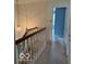 Hallway with a view of a bedroom and stairs with a hanging light fixture at 8002 Windham Lake Way # 33, Indianapolis, IN 46214