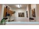 View of kitchen area with wooden cabinets, artwork and a pass-through overlooking another room at 8002 Windham Lake Way # 33, Indianapolis, IN 46214