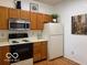 Eat-in kitchen featuring white countertops, appliances and wood cabinets at 8002 Windham Lake Way # 33, Indianapolis, IN 46214