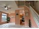 Inviting living room featuring a staircase, a ceiling fan, and views into the adjacent kitchen at 8002 Windham Lake Way # 33, Indianapolis, IN 46214