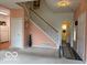 Open-concept living room with staircase, neutral carpet, and doorway view to kitchen at 8002 Windham Lake Way # 33, Indianapolis, IN 46214