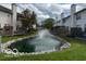 A serene pond with a fountain surrounded by green grass and townhomes at 8002 Windham Lake Way # 33, Indianapolis, IN 46214