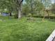 Lush green backyard featuring mature trees and a fire pit at 802 Suwanee Ct, Indianapolis, IN 46217