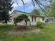 Exterior side view of home with lush green backyard and decorative shrubbery at 802 Suwanee Ct, Indianapolis, IN 46217