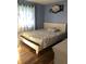 Cozy bedroom features hardwood floors, a white platform bed, and decorative rose wall art at 802 Suwanee Ct, Indianapolis, IN 46217
