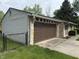 Side view of the stone home featuring an attached garage and fenced yard at 802 Suwanee Ct, Indianapolis, IN 46217