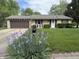 Charming stone home featuring a well-manicured lawn and beautiful blooming irises at 802 Suwanee Ct, Indianapolis, IN 46217