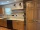 Kitchen featuring stainless steel appliances, modern sink, light wood cabinets and an accent wall at 8234 Crosser Dr, Indianapolis, IN 46237