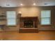 Living room features a brick fireplace with two windows with blinds on each side and hardwood floors at 8234 Crosser Dr, Indianapolis, IN 46237