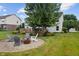 Inviting backyard with mature tree, fire pit surrounded by Adirondack chairs, and wooden deck at 8316 Thorn Bend Dr, Indianapolis, IN 46278