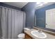 Cozy bathroom features a vanity, sink, toilet and shower with blue walls and tile at 8316 Thorn Bend Dr, Indianapolis, IN 46278