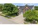 Classic brick home with lush landscaping, a large driveway, and an attached two-car garage on a sunny day at 8316 Thorn Bend Dr, Indianapolis, IN 46278