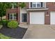 Inviting front entrance with a brick facade, a two-car garage, and manicured landscaping at 8316 Thorn Bend Dr, Indianapolis, IN 46278