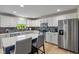 Modern kitchen with white cabinetry, stainless steel appliances, an island with barstool seating, and tiled backsplash at 8316 Thorn Bend Dr, Indianapolis, IN 46278