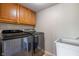 Functional laundry room with a modern washer and dryer set, upper cabinets, and a utility sink at 8316 Thorn Bend Dr, Indianapolis, IN 46278