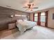 Bedroom with a decorative accent wall, lighted ceiling fan and two windows at 8798 Surrey Dr, Pendleton, IN 46064