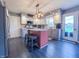 Bright kitchen with white cabinets, modern lighting, stainless steel fridge and an island at 8798 Surrey Dr, Pendleton, IN 46064