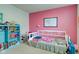 Bright bedroom with pink accent wall, white wood bed frame, and fun decor details at 900 Sunchaser Rd, Lebanon, IN 46052