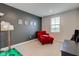This bedroom has a red lounge chair and a black accent wall at 900 Sunchaser Rd, Lebanon, IN 46052