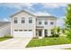 Charming two-story home featuring a well-manicured lawn and attached two-car garage on a sunny day at 900 Sunchaser Rd, Lebanon, IN 46052
