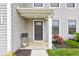 A close-up of the front door is framed by colorful landscaping and charming architectural details at 900 Sunchaser Rd, Lebanon, IN 46052