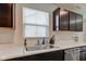 Kitchen sink area featuring black cabinets, marble countertops, and natural lighting at 900 Sunchaser Rd, Lebanon, IN 46052