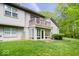 Back exterior with sunroom, upper-level deck, siding, green lawn and plenty of trees at 9317 Muir Ln, Fishers, IN 46037
