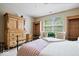 Bright bedroom with an antique dresser, wardrobe, and a metal bed frame with a window view at 9317 Muir Ln, Fishers, IN 46037