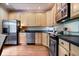 Kitchen features light wood cabinets, stainless steel appliances, and solid surface countertops at 9317 Muir Ln, Fishers, IN 46037
