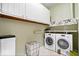 Well-lit laundry room with washer, dryer, cabinetry, shelving, and front load machines at 9317 Muir Ln, Fishers, IN 46037