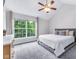 Comfortable carpeted bedroom with a large window overlooking mature trees and a ceiling fan at 952 Junction Pl, Indianapolis, IN 46220