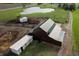 Aerial view of barn with green roof, various outbuildings and an adjacent pond at 9621 N County Road 25 W, Muncie, IN 47303