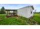 Exterior view of a home with white siding and a covered wooden deck at 9621 N County Road 25 W, Muncie, IN 47303
