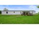 A single-story home with white siding and a covered wooden deck in a grassy yard at 9621 N County Road 25 W, Muncie, IN 47303
