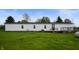Ranch-style home with white siding, dark roof, deck and a large lawn at 9621 N County Road 25 W, Muncie, IN 47303