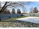 Wide, fenced backyard with tree, partial snow covering, and some shrubbery around the perimeter at 9955 Orange Blossom Trl, Fishers, IN 46038