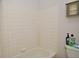 Clean bathroom with white tiled walls and a white bathtub at 9955 Orange Blossom Trl, Fishers, IN 46038